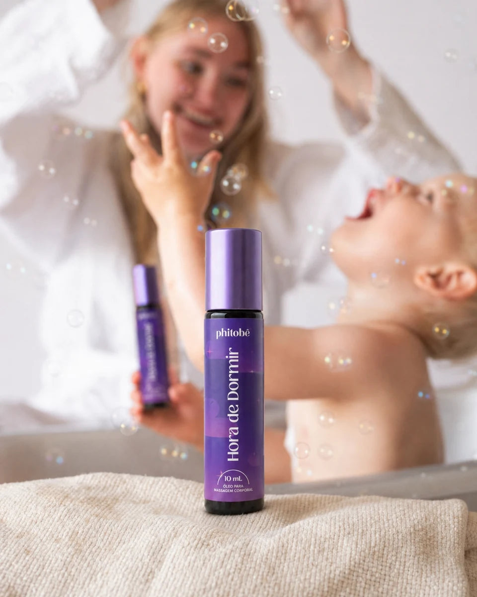 Mãe brincando com o bebê ao lado do roll-on Hora de Dormir